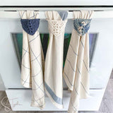 3 dish towels with crochet tops hanging from an oven