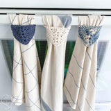 3 dish towels with crochet tops hanging from an oven
