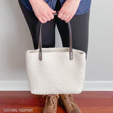 woman holding crochet bag with leather straps