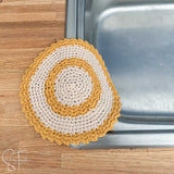 yellow and cream dishcloth draped on the side of a sink