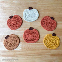 six crocheted pumpkin coasters of various fall colors laid flat