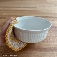 crochet potholder being used to hold an empty dish