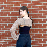 teen showing the back of a crochet mesh crop sweater