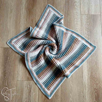 striped crochet waffle stitch baby blanket on the floor