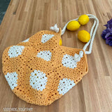 crochet bag filled with lemons spilling out resting on a counter
