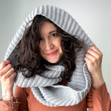 woman wearing a gray ribbed scarf as a hood over her head