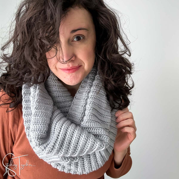 woman wearing and orange shirt and a gray ribbed  crochet scarf