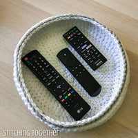 crocheted bowl with tv remotes in it