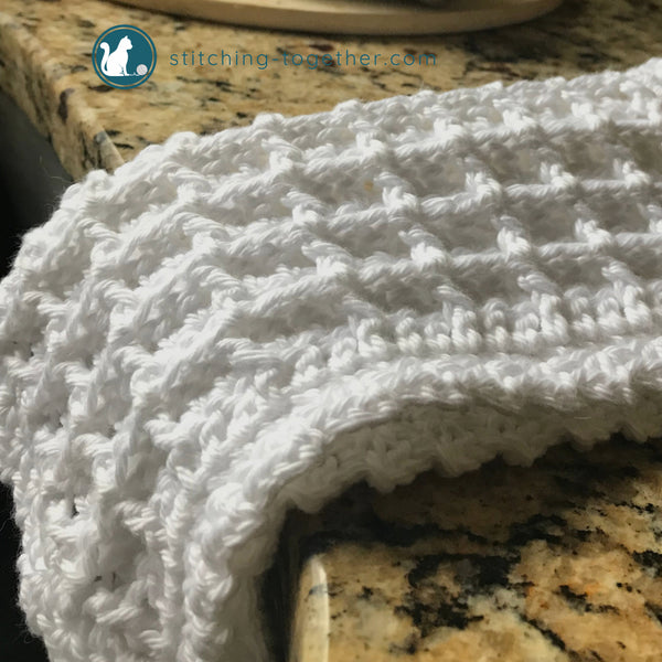 white crochet waffle stitch dishcloth folded on counter