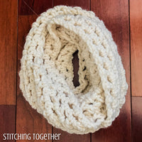 chunky crochet infinity scarf on a wood floor
