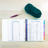3 ring binder with yarn weights printable and hook sizes printable next to a crochet hook and yarn
