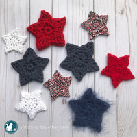multiple crochet stars in different colors laying on a desk