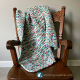 crochet baby blanket draped on small rocking chair