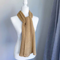 tan lacy crochet scarf around the neck of a mannequin 