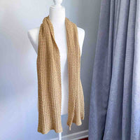 golden tan colored crochet scarf draped around the neck of a mannequin