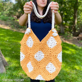 crochet market bag being held up by a lady