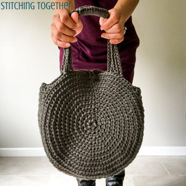 gray crochet circle bag being held