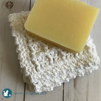 bar of soap on top of a folded white crochet dishcloth