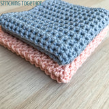 gray and pink crochet washcloths folded