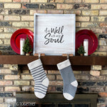 2 crochet christmas stockings hanging on a decorated mantle