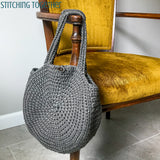 gray circle bag hanging on chair
