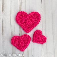 three pink crochet heart of different sizes