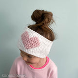 girl wearing crochet heart ear warmer