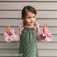 little girl wearing pink crochet shrug with ruffles