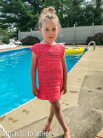 girl wearing a crochet girls dress while standing by a pool