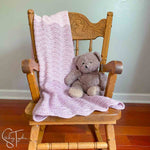 ripple stitch baby blanket draped on small rocking chair