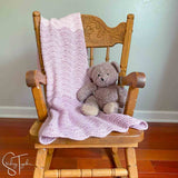 ripple stitch baby blanket draped on small rocking chair