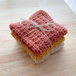 three crochet washcloths folded and stacked and wrapped with jute twine