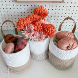 3 crochet baskets filled with yarn and flowers