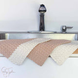 3 crochet dishcloths on the side of a sink