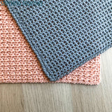 gray and pink crochet washcloths with different textures laying flat