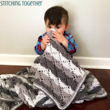 baby holding diamond lace crochet blanket