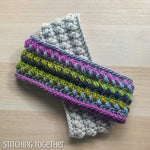 a colorful crochet ear warmer on top of a neutral ear warmer