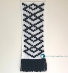 black and white crochet wall hanging with black fringe