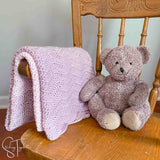ripple stitch baby blanket folded on small rocking chair