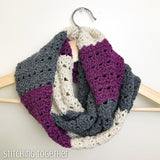 looped crocheted infinity scarf with stripes on a hanger
