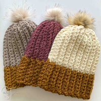 2 bulky crochet hats with pom poms laying flat