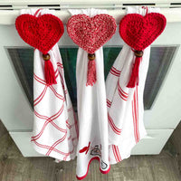 valentine dish towels with heart crochet towel toppers hanging on an oven